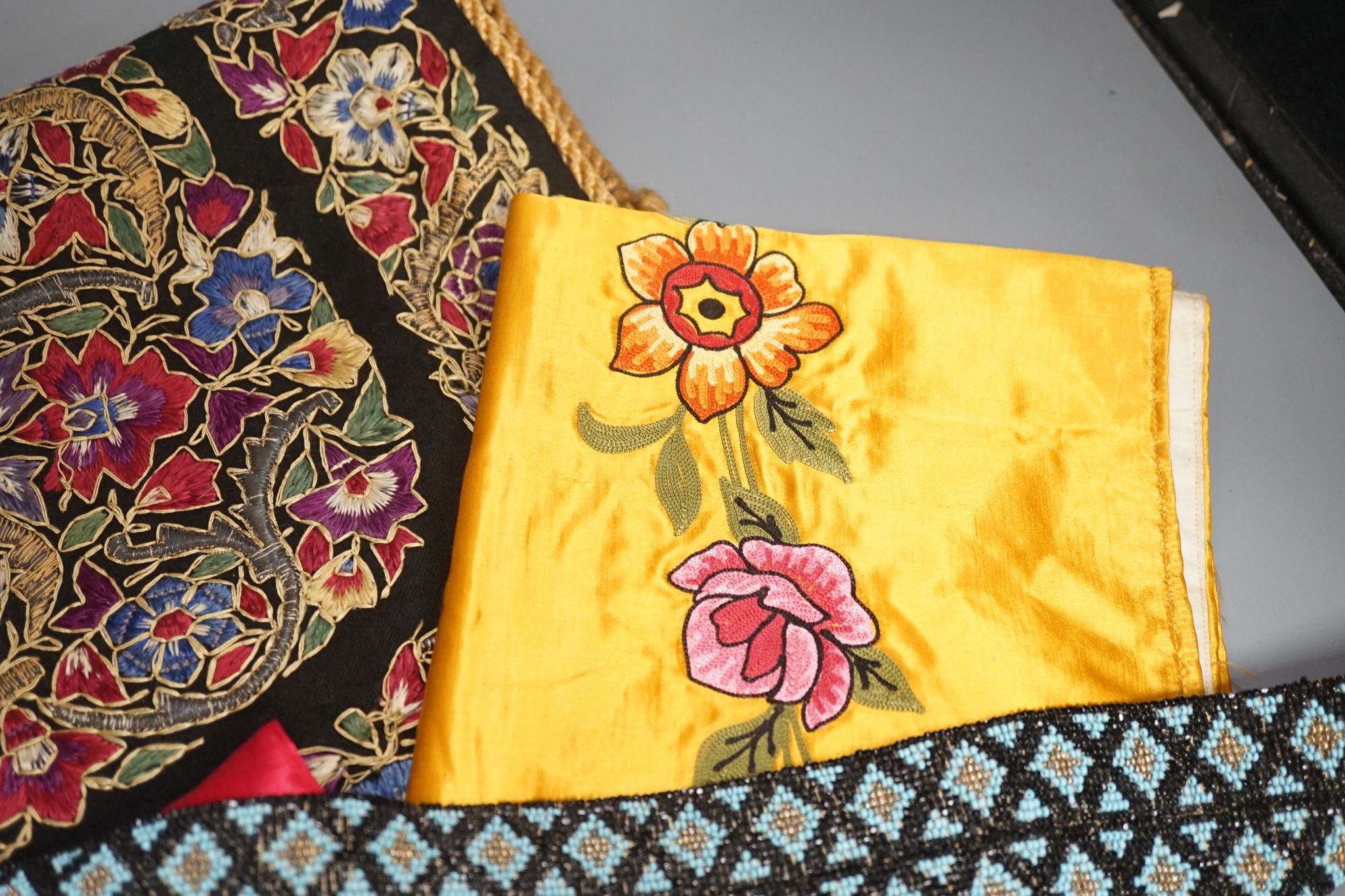 A Berlin beadwork panel , another, a beaded cushion, a book and embroidered banners, 2 silk panels etc
